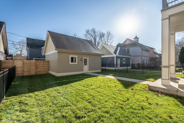 rear view of house featuring a yard and an outdoor structure