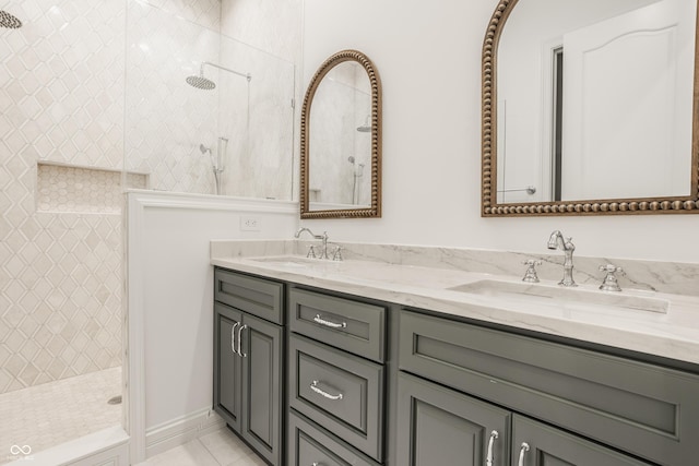 bathroom featuring tile patterned flooring, vanity, and tiled shower