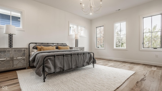 bedroom with a notable chandelier and light hardwood / wood-style floors