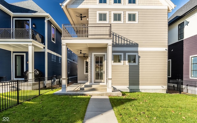 exterior space with ceiling fan, a lawn, and a balcony