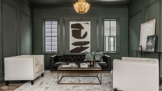 sitting room with a notable chandelier, crown molding, and wood-type flooring