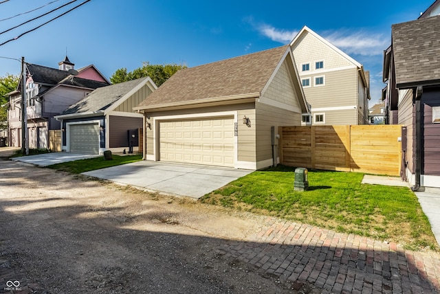 view of front of home featuring an outbuilding, a garage, and a front lawn