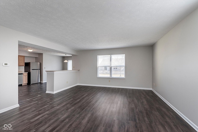 unfurnished living room featuring dark hardwood / wood-style flooring and a textured ceiling