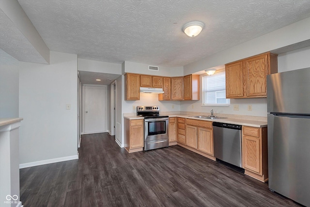 kitchen featuring sink, dark wood-type flooring, stainless steel appliances, and a textured ceiling