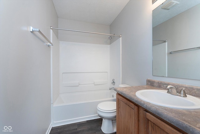 full bathroom featuring toilet, a textured ceiling, shower / washtub combination, vanity, and hardwood / wood-style flooring