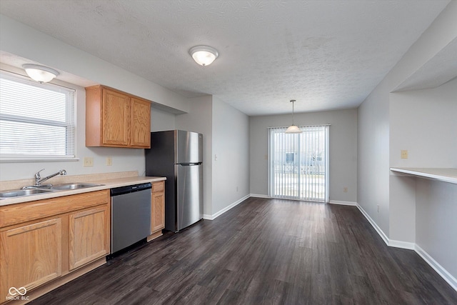 kitchen featuring sink, appliances with stainless steel finishes, dark hardwood / wood-style floors, a textured ceiling, and decorative light fixtures