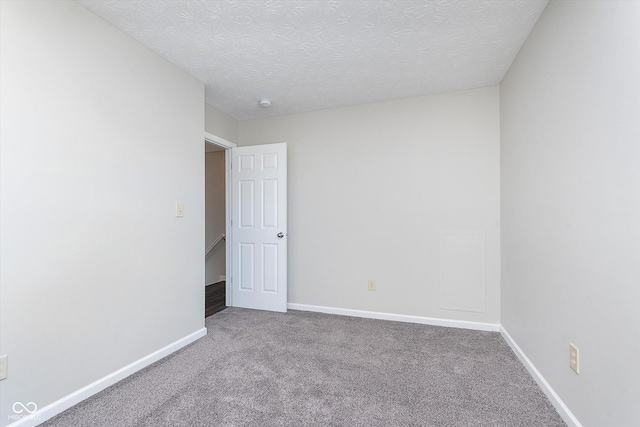 unfurnished room featuring carpet and a textured ceiling