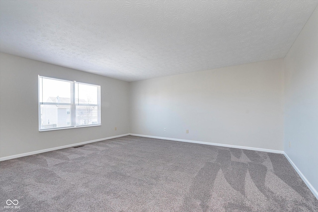 spare room featuring carpet floors and a textured ceiling