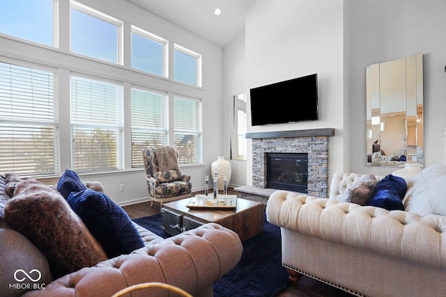 living room with hardwood / wood-style floors, a fireplace, and a high ceiling