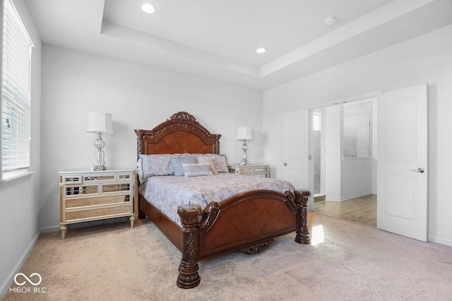 bedroom with a raised ceiling and carpet floors