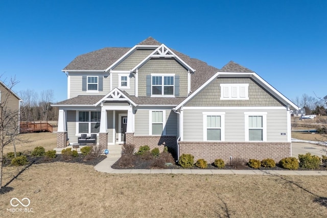 craftsman inspired home featuring covered porch and a front lawn