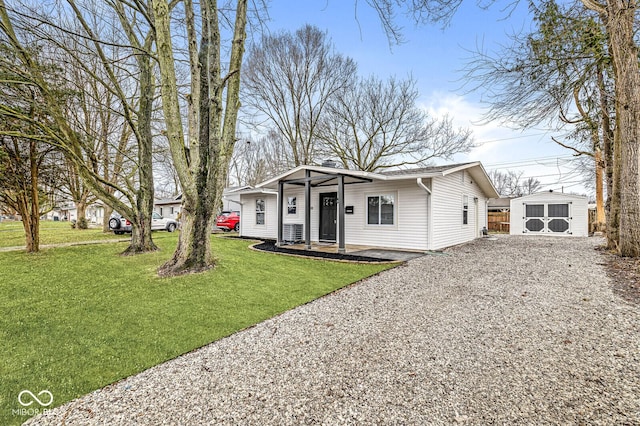 view of front of home featuring an outdoor structure and a front yard