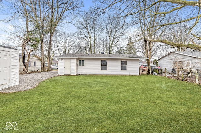 back of house with a yard and a storage shed