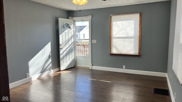 interior space featuring ceiling fan, dark hardwood / wood-style flooring, and a textured ceiling