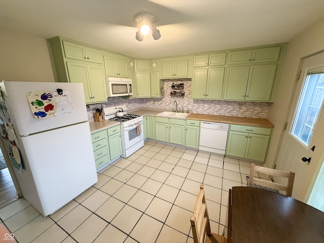 kitchen featuring tasteful backsplash, sink, white appliances, and green cabinets