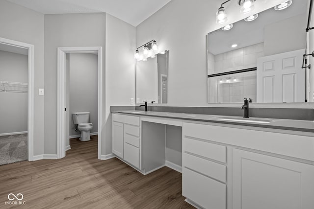 bathroom featuring toilet, an enclosed shower, vanity, and wood-type flooring