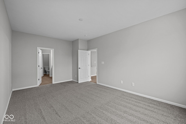 unfurnished bedroom featuring carpet floors and ensuite bath