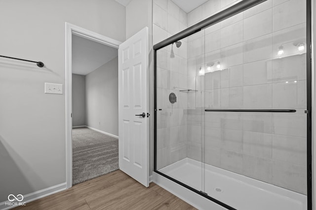 bathroom with hardwood / wood-style flooring and a shower with door