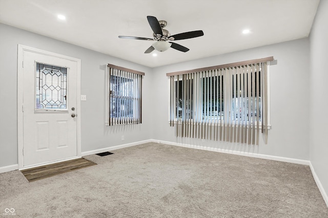 carpeted foyer entrance featuring ceiling fan