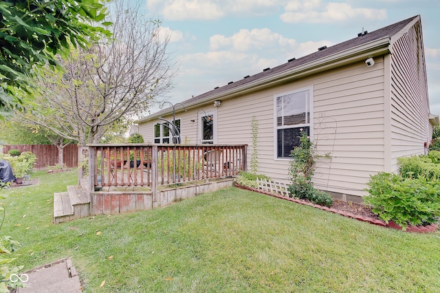 rear view of property with a lawn and a deck