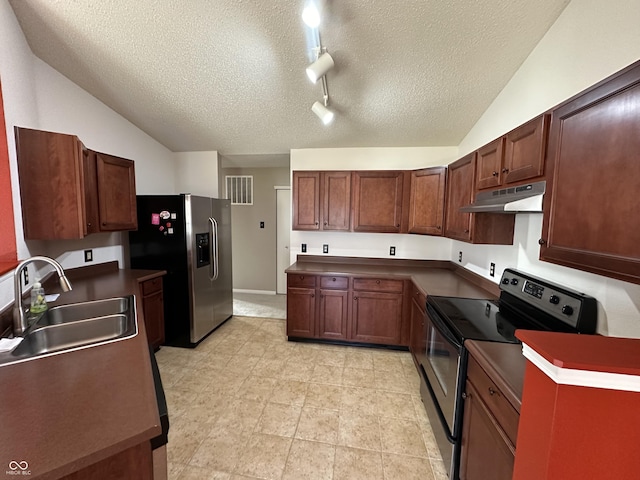 kitchen featuring vaulted ceiling, stainless steel appliances, sink, and a textured ceiling