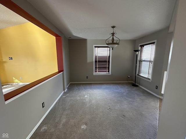 spare room featuring carpet floors and a textured ceiling