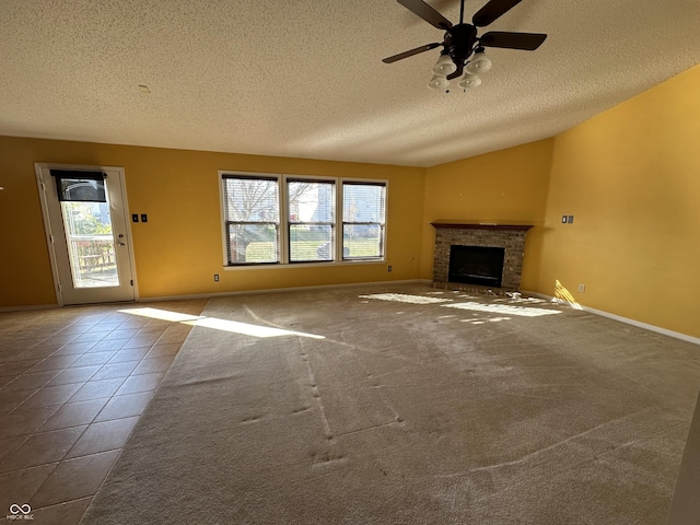 unfurnished living room with ceiling fan, a healthy amount of sunlight, tile patterned floors, and a fireplace