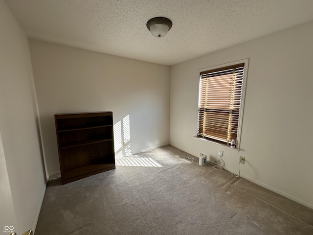 carpeted spare room featuring a textured ceiling