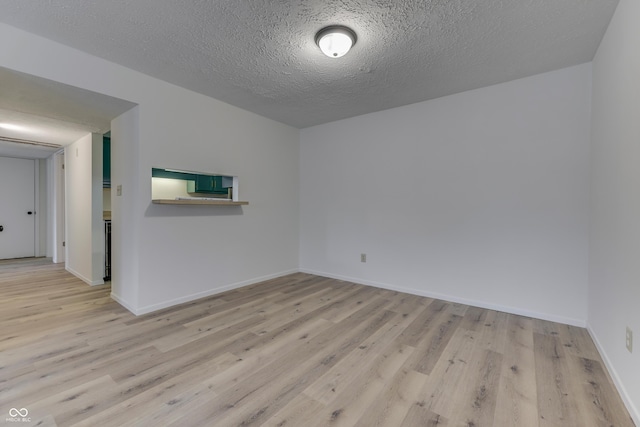 empty room featuring a textured ceiling and light wood-type flooring