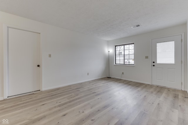 entrance foyer featuring a textured ceiling and light wood-type flooring