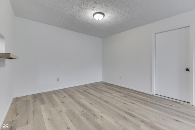 empty room featuring a textured ceiling and light wood-type flooring