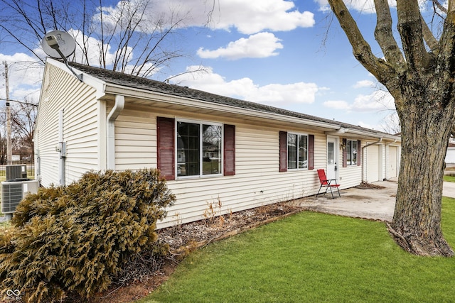 view of front facade featuring a garage, a front yard, and central air condition unit