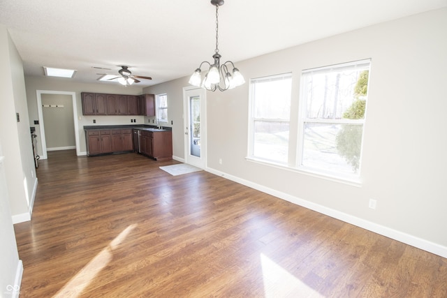 kitchen featuring dark brown cabinets, dark wood-type flooring, sink, and decorative light fixtures