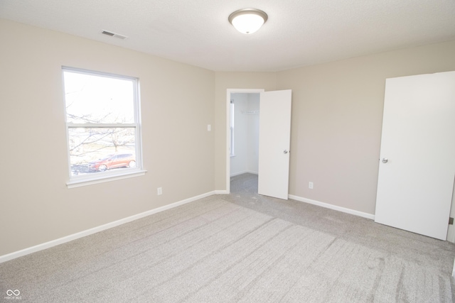 carpeted empty room featuring a textured ceiling