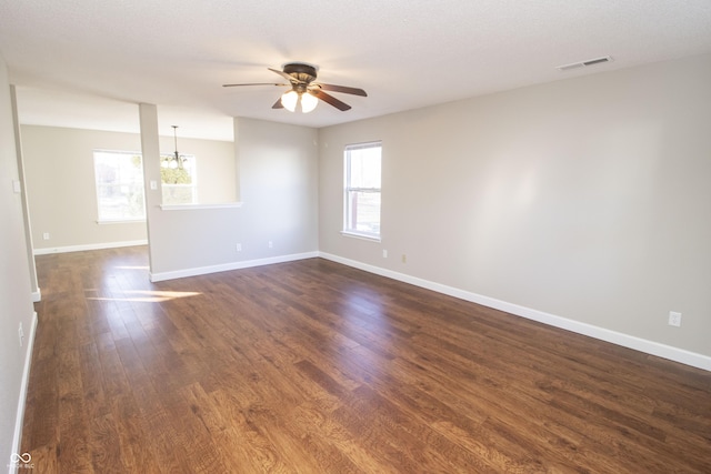 unfurnished room featuring ceiling fan with notable chandelier and dark hardwood / wood-style flooring