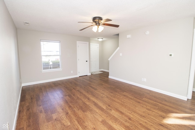 spare room featuring dark hardwood / wood-style floors, a textured ceiling, and ceiling fan