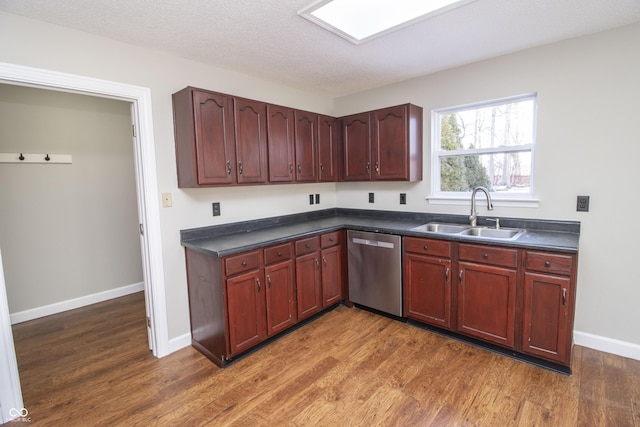 kitchen with dark hardwood / wood-style flooring, dishwasher, sink, and a textured ceiling