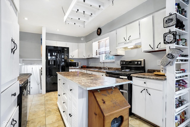 kitchen with sink, a center island, light tile patterned floors, appliances with stainless steel finishes, and white cabinets