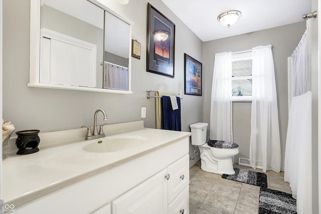 bathroom with vanity, toilet, and tile patterned flooring