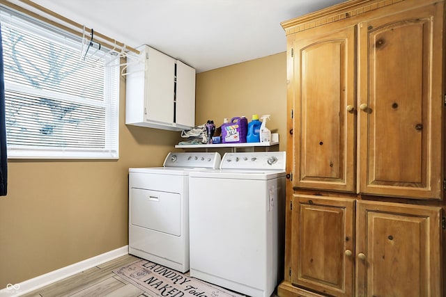 washroom with cabinets, separate washer and dryer, and light hardwood / wood-style flooring