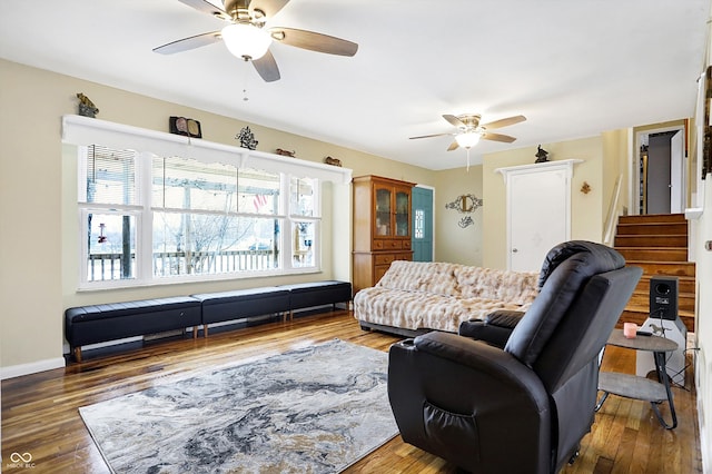 living room featuring dark wood-type flooring and ceiling fan