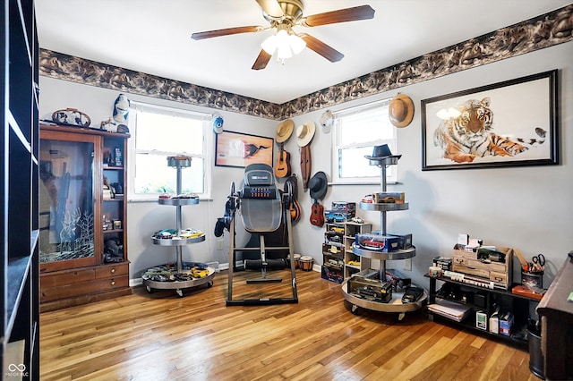 workout area featuring ceiling fan and light wood-type flooring