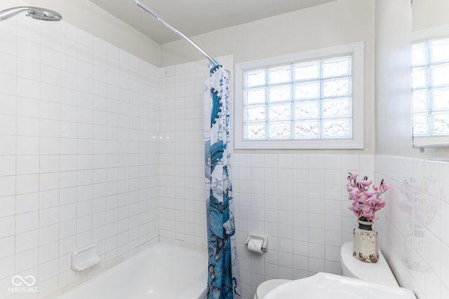 bathroom featuring tile walls, shower / tub combo with curtain, and toilet