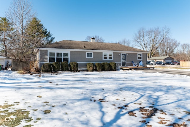 snow covered rear of property featuring a wooden deck