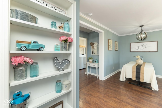 dining space with dark hardwood / wood-style flooring, a notable chandelier, crown molding, and washer / dryer