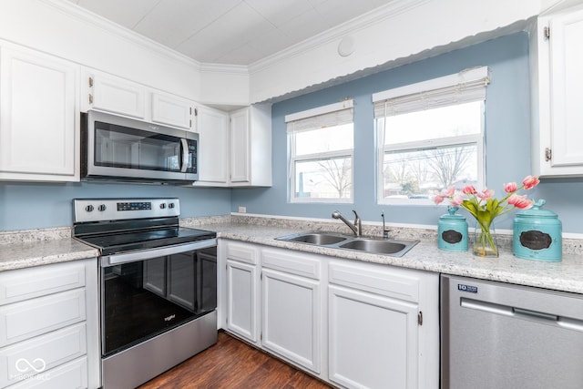 kitchen featuring dark hardwood / wood-style floors, sink, white cabinets, ornamental molding, and stainless steel appliances