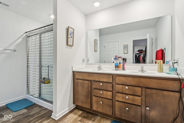 bathroom featuring walk in shower, wood-type flooring, and vanity