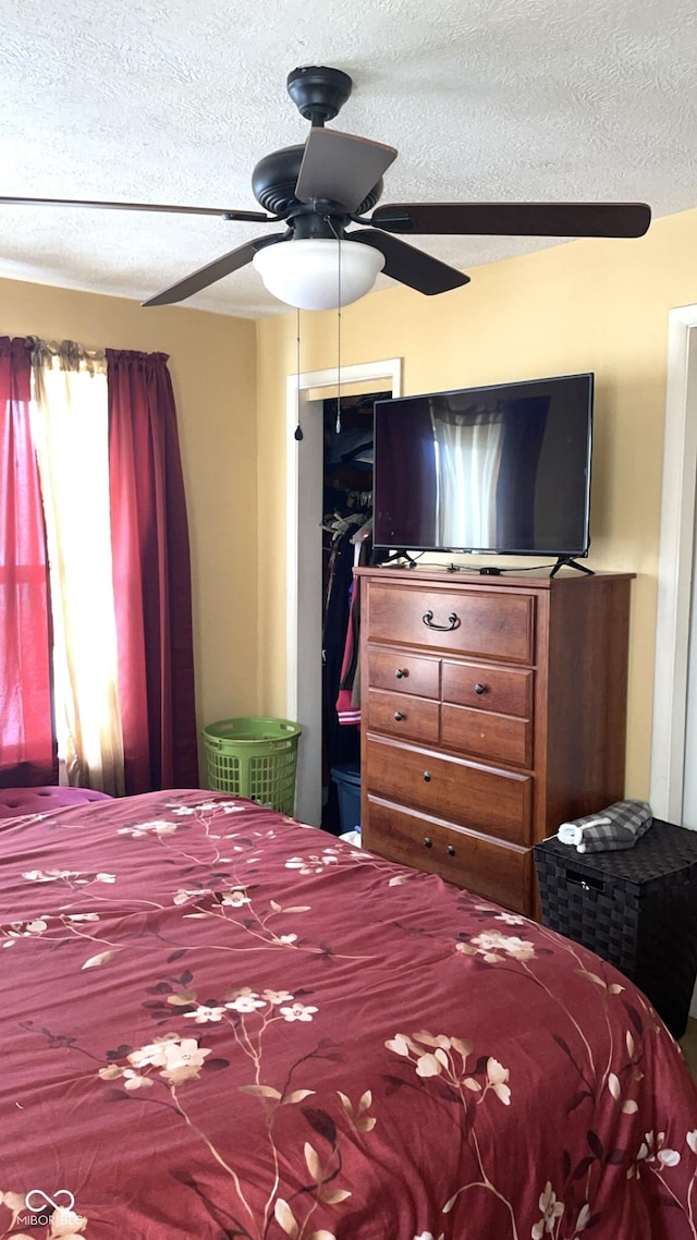 bedroom with ceiling fan and a textured ceiling