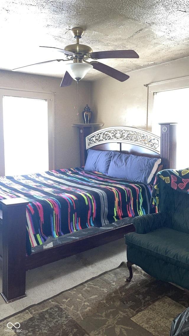 bedroom featuring ceiling fan and a textured ceiling