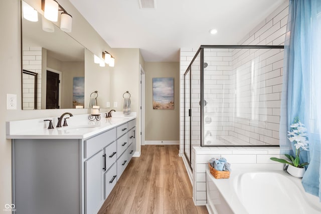 bathroom featuring hardwood / wood-style flooring, vanity, and independent shower and bath